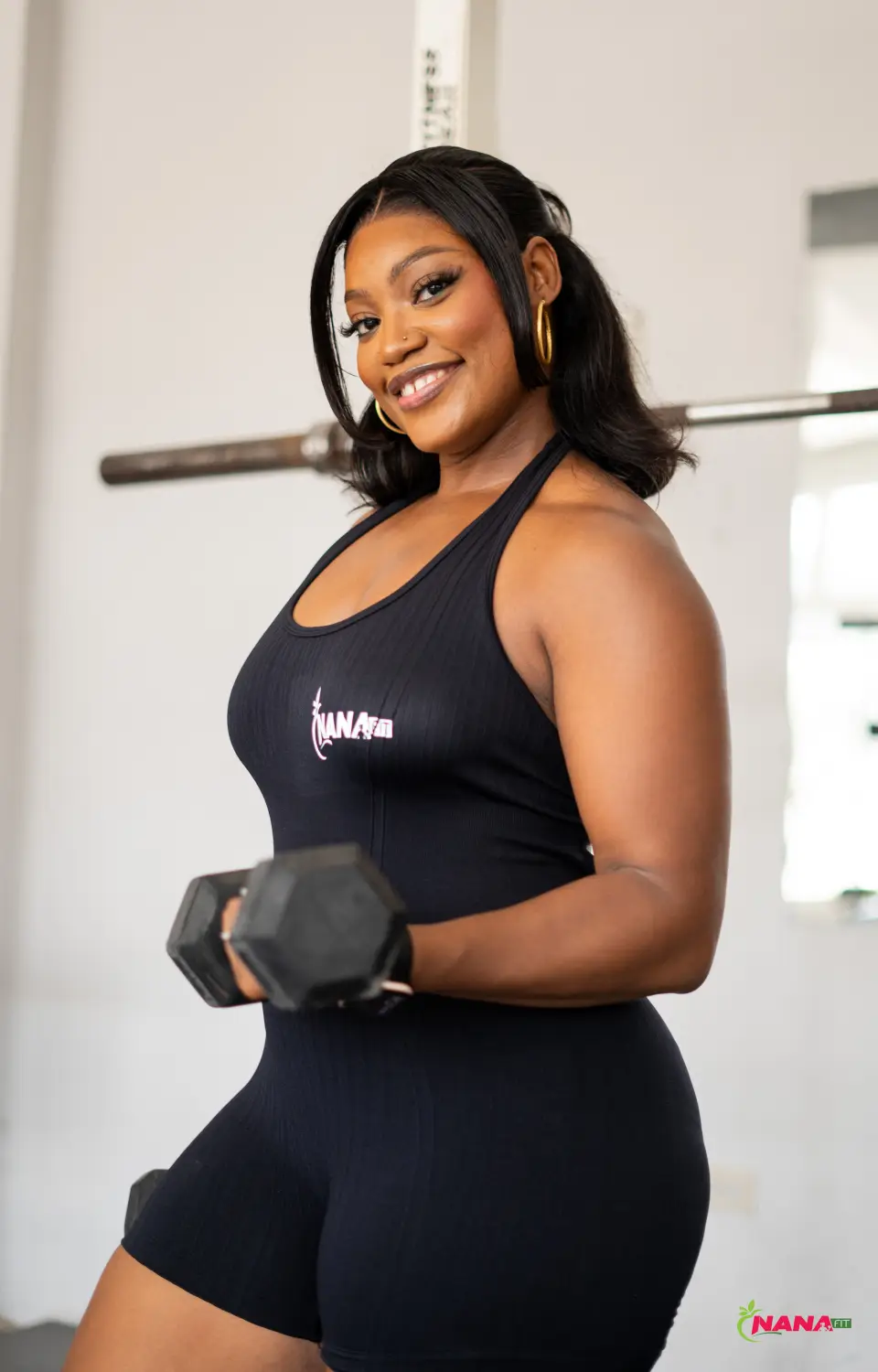 Coach NanaFit souriante, haltère en main